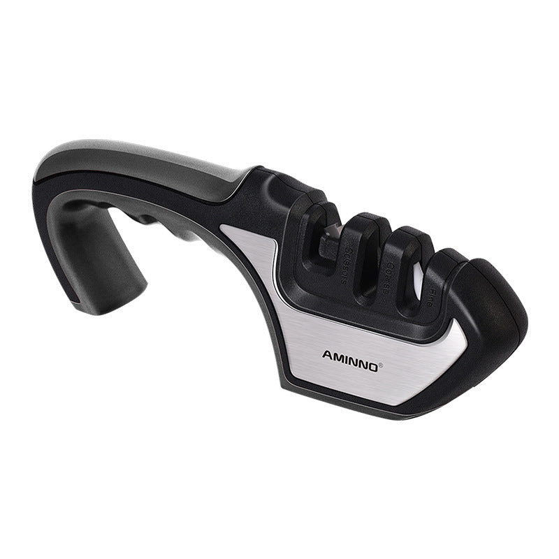 Une famille quatre-en-un utilise un aiguiseur pour aiguiser un couteau de cuisine