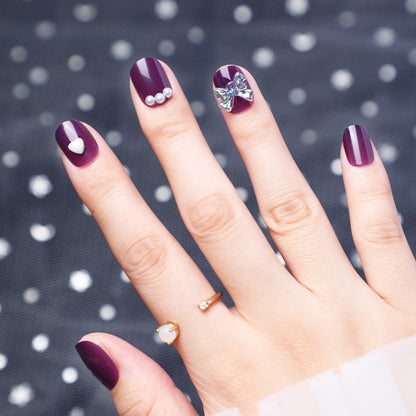 Usar uñas con diamantes y uñas postizas moradas